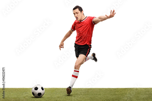 Young football player kicking a ball