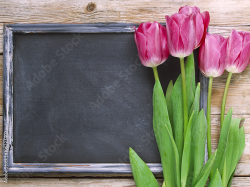 Fototapeta Naklejka Na Ścianę i Meble -  Blackboard and purple tulips on the wood background.