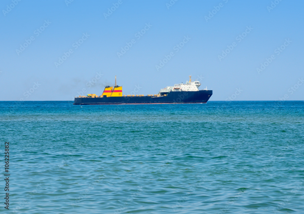 Cargo ship in the sea against the blue sky