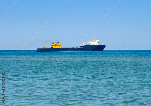 Cargo ship in the sea against the blue sky