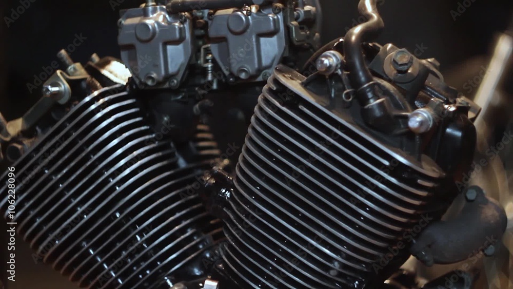 V-shaped engine - auto mechanic assembles custom motorcycle in his workshop. Create an exclusive moto bike in the garage. V-shaped engine - auto mechanic assembles custom motorcycle in his workshop. Create an exclusive moto bike in the garage.
