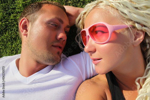 Young stylish sensual couple in love outdoor, tropical green grass.