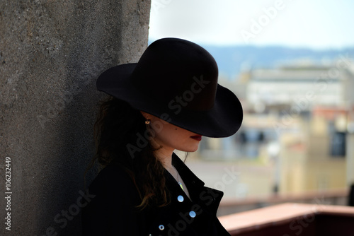 Photography Portrait of beautiful woman in hat in profile on terrace in Barcelona, Spain