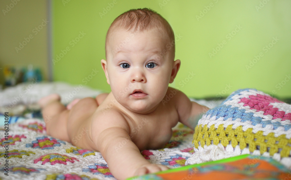 Little boy lying on his stomach and looks.. Little boy lying on his stomach and looks..
