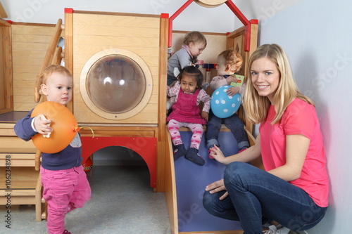 Erzieherin mit 4 Kindern an Spielgerät 2 photo