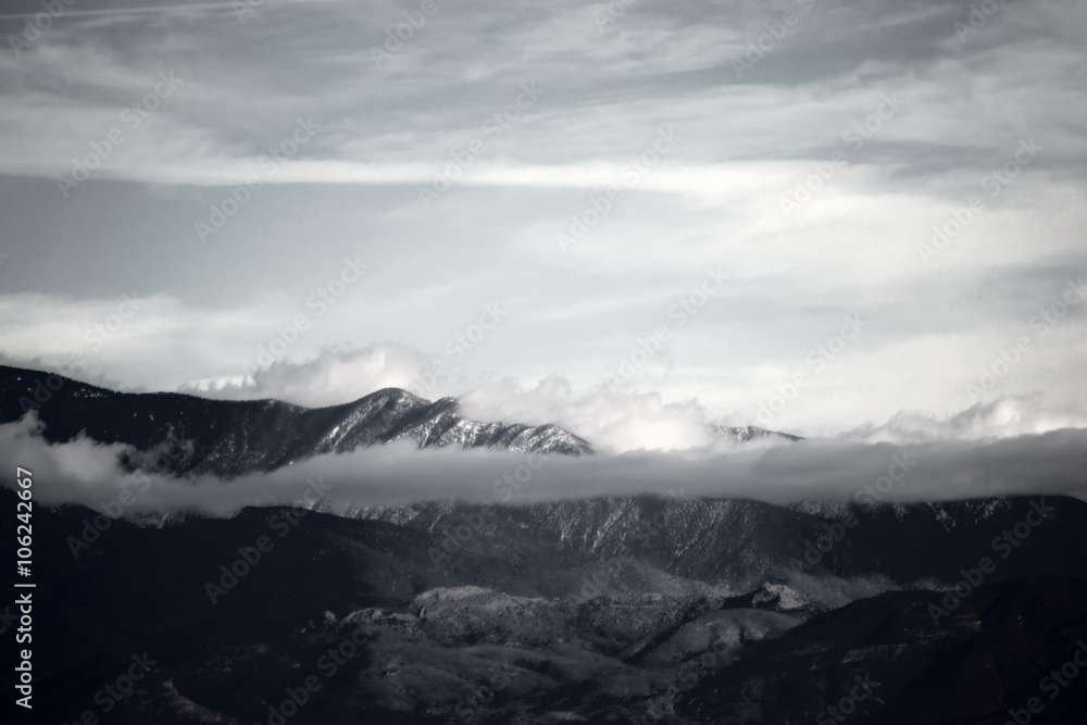 Wolken ziehen über die Berge / Wolken und Nebel ziehen über die Gipfel und Bergrücken eines Gebirges beziehungsweise Bergkette.