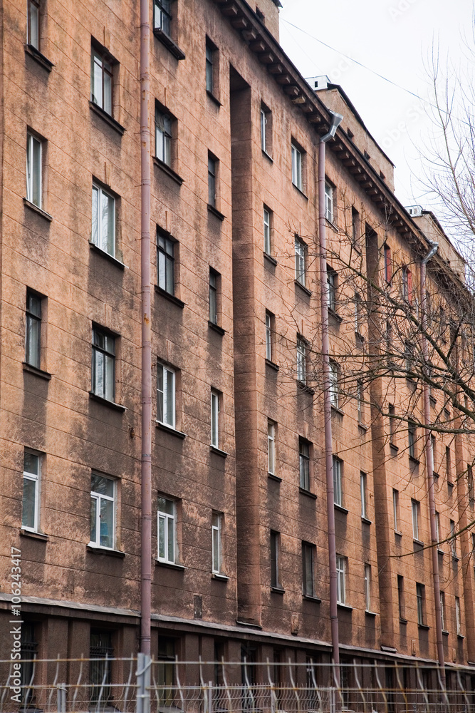 Fototapeta premium Facade of a multi-storey old house with windows