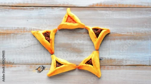 Woman hand creating a Star of David made out of Purim Cookies - Hamentashen (Ozen Haman) for Purim Jewish Holiday. Copy space photo