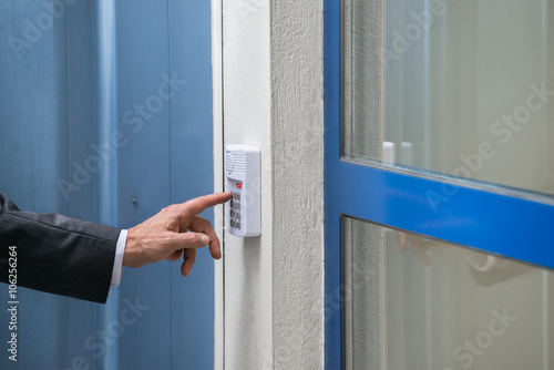 Close-up Of Businessman Using Door Security System On Wall