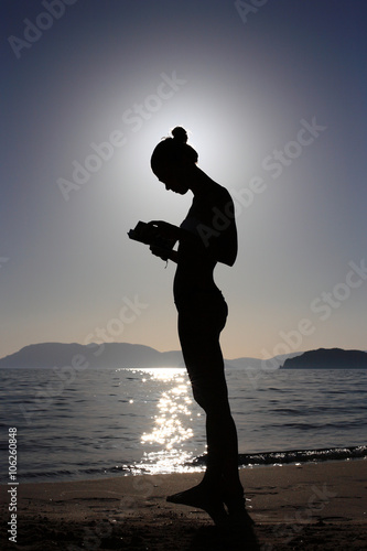 silhouette of a girl with a book