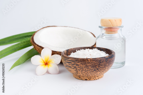 coconut oil in a bottle  background is a half of coconut  isolated
