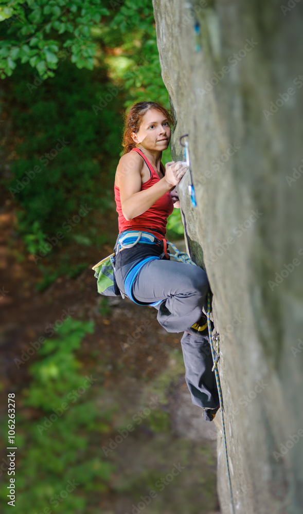 Young female rock climber on a cliff wall getting ready to make her next move on her challenging route. Healthy lifestyle concept. Climbing equipment. Young female rock climber on a cliff wall getting ready to make her next move on her challenging route. Healthy lifestyle concept. Climbing equipment.