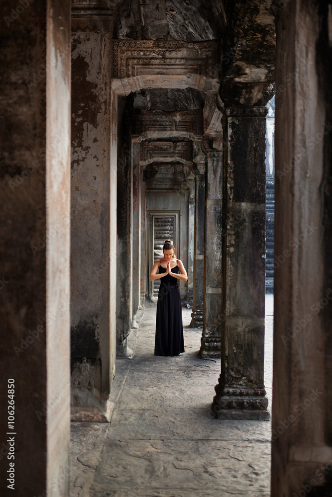Religion And Meditation. Beautiful Religious Woman Praying, Meditating In Corridor At Prasat Angkor Wat Temple, Siem Reap, Cambodia. Buddhism. Famous Landmark, Tourist Attraction, Travel To Asia.