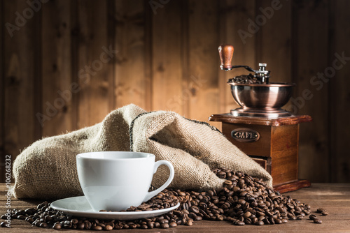 still life with coffee beans and old coffee mill on the wooden background photo