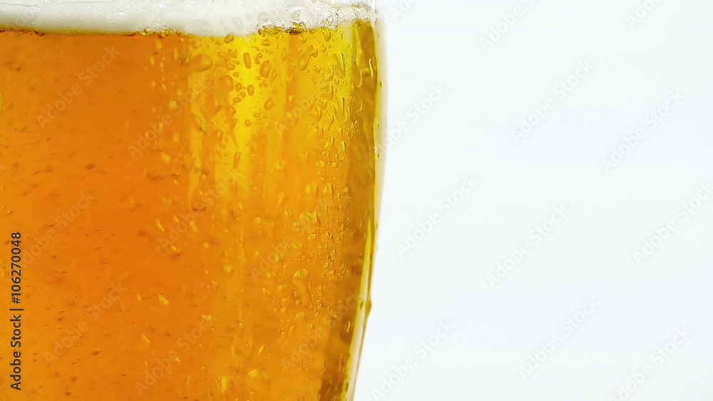 detail of pouring fresh beer with foam into glass on white background detail of pouring fresh beer with foam into glass on white background