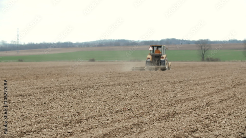 Agricultural tractor sowing and cultivating field Agricultural tractor sowing and cultivating field