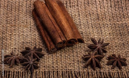 spices cinnamon sticks brown and anise stars on sacking