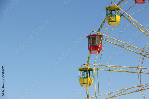 Color cabins of a ferris wheel against the blue sky