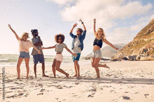 Happy young people dancing on the beach