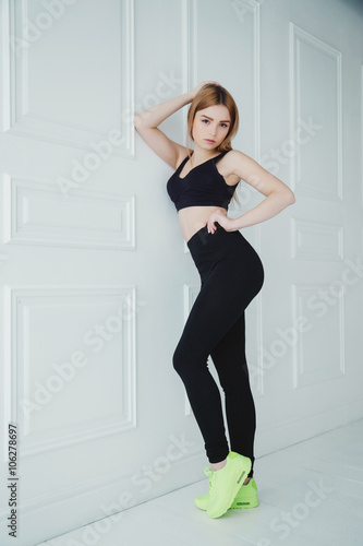 Studio photo of beautiful girl with sportive body, wearing sport clothes