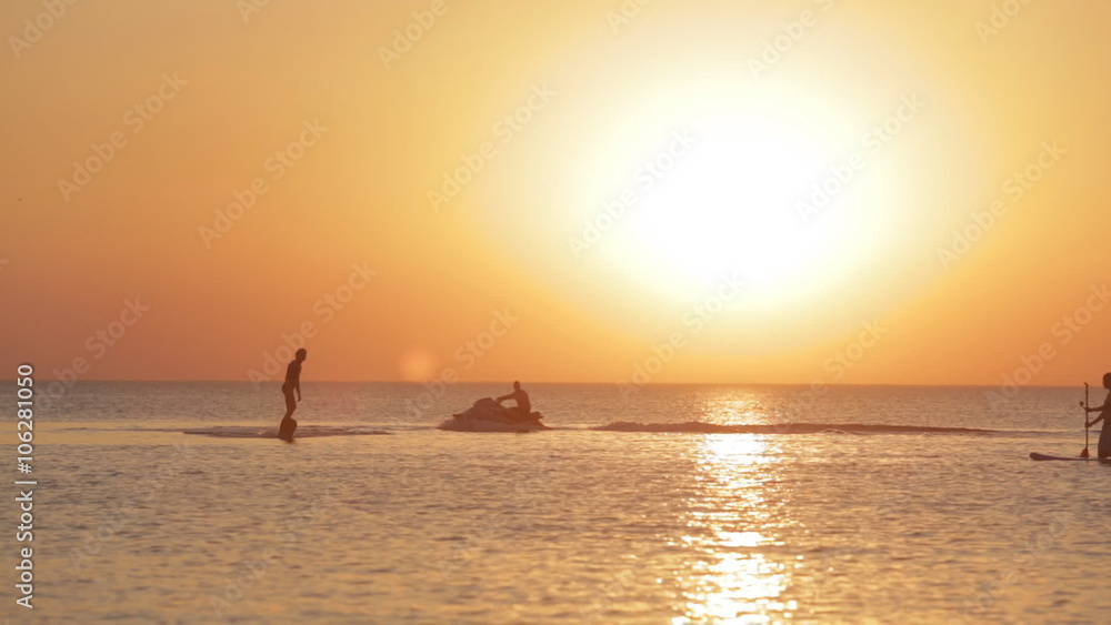 Silhouette of a Man Having Fun on Flyboard in the Sea at Sunset Background Silhouette of a Man Having Fun on Flyboard in the Sea at Sunset Background