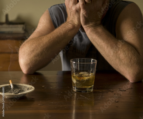Desperate times - middle-aged man seeks solace in alcohol, moody lighting
