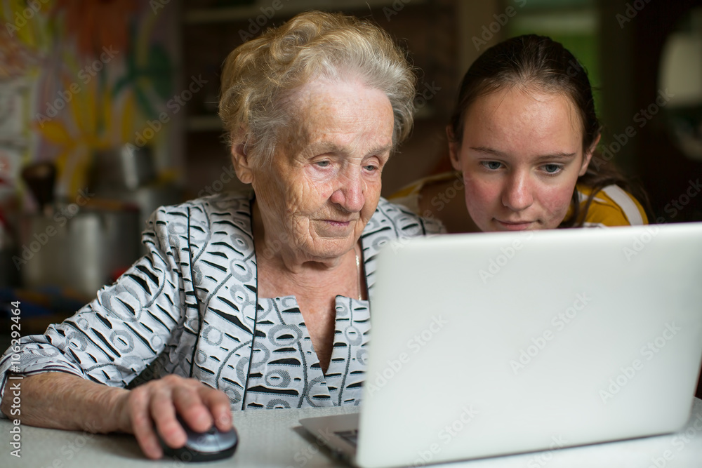 Elderly woman with her granddaughter working on laptop. Elderly woman with her granddaughter working on laptop.
