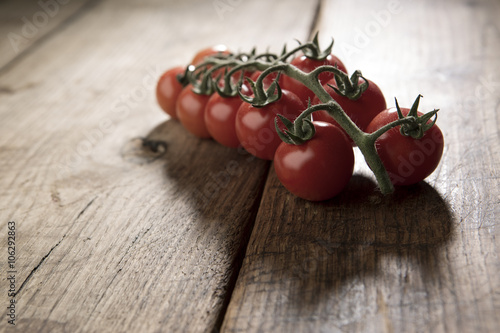 controluce di pomodori a grappolo isolati su sfondo legno photo