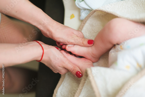 Mother holds feets of newborn baby
