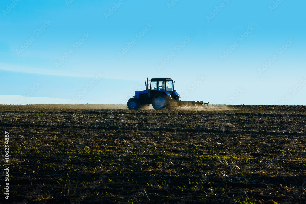 Tractor plows a field in the spring before sowing campaign Tractor plows a field in the spring before sowing campaign
