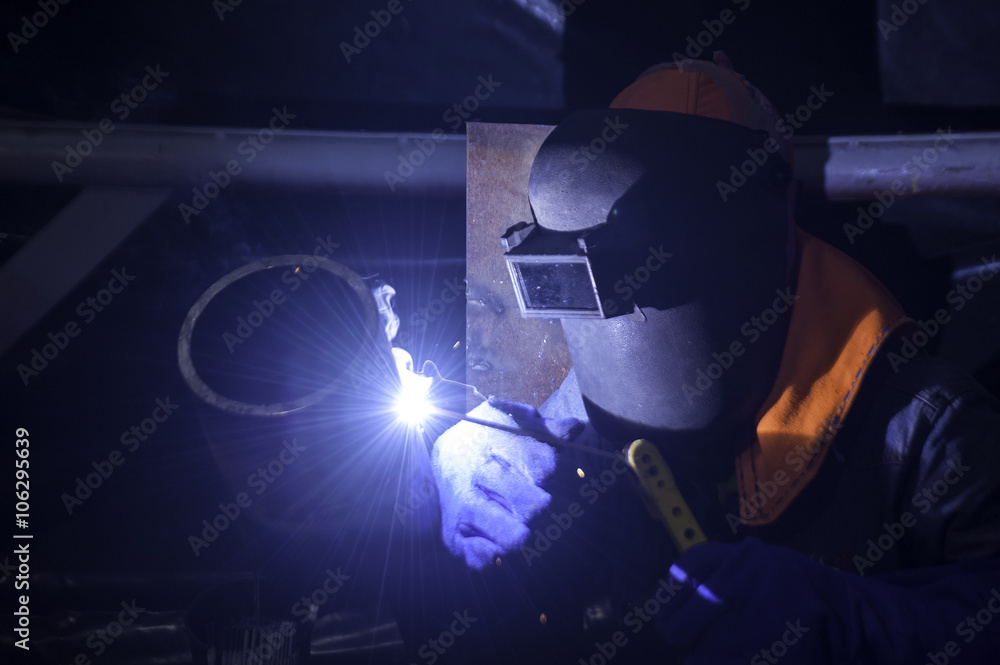 Worker welding pipes structure with welder machine Worker welding pipes structure with welder machine