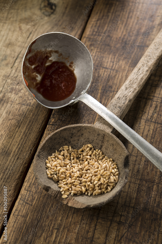 dettaglio di accessori antichi da cucina con grano su un mestolo e sfondo  tavola di legno scuro Stock Photo | Adobe Stock