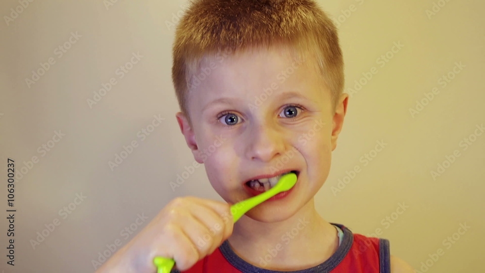 Boy brushing his teeth with a brush close Boy brushing his teeth with a brush close