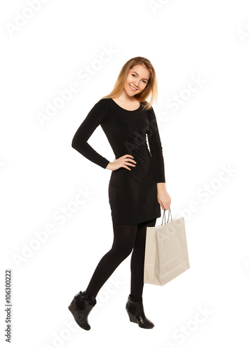 Young woman in a black dress with shopping bags, isolated on a w