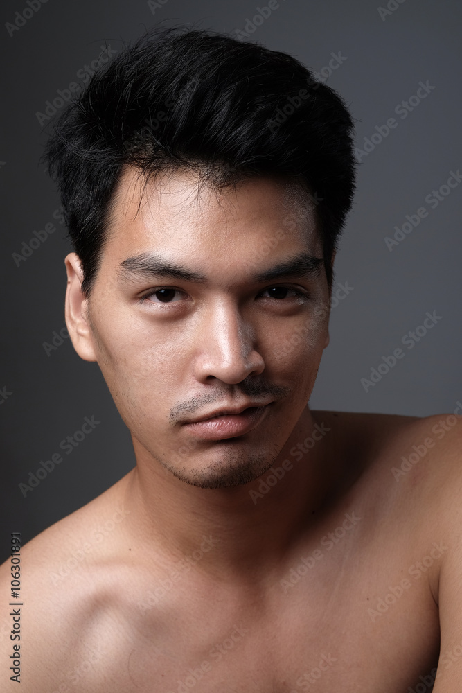 Asian man portrait with no makeup show his real skin in grey background - soft focus Asian man portrait with no makeup show his real skin in grey background - soft focus