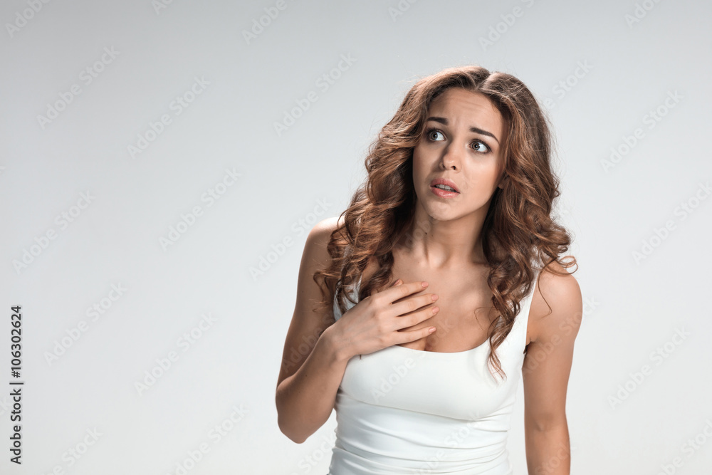 Woman is looking imploring over gray background Woman is looking imploring over gray background