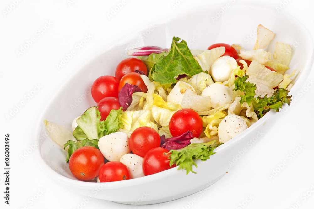 Vegetable salad in a white plate with chicken on white background
