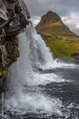 Kirkjufell  463 m. high mountain on the north coast of Iceland s Snaefellsnes peninsula  seen from the base of the near by waterfall.