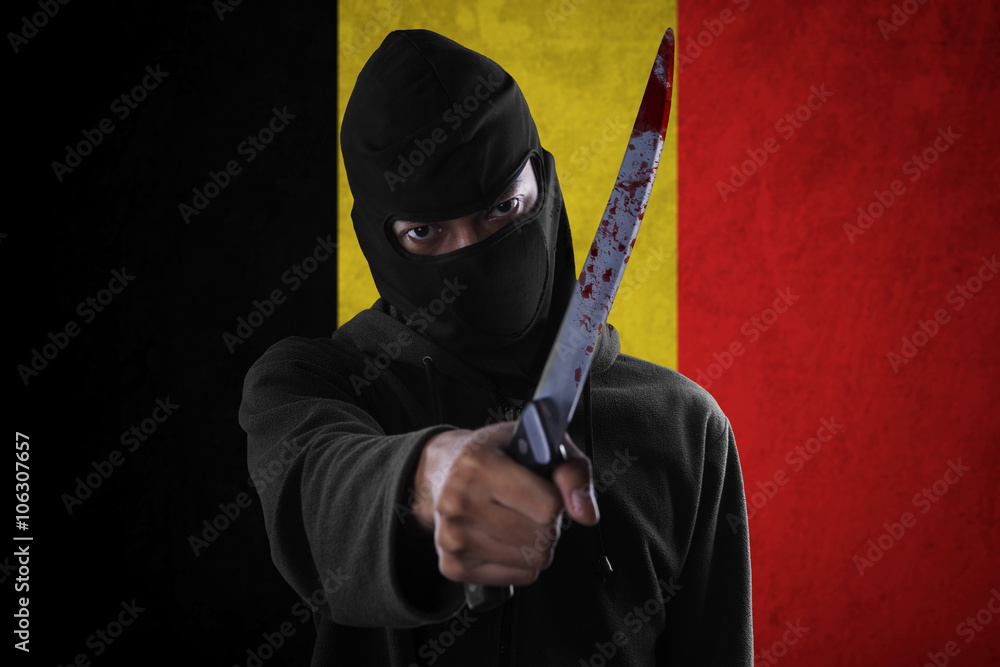 Portrait of man threatening with knife while standing against Belgium flag Portrait of man threatening with knife while standing against Belgium flag