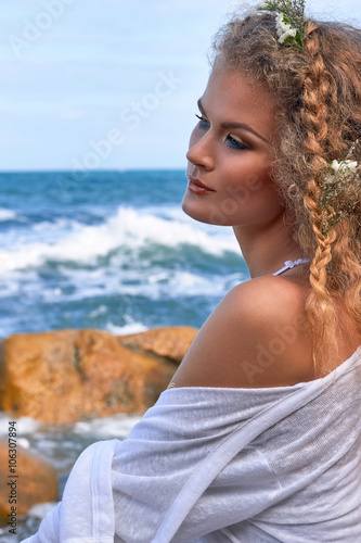  pretty curly woman portrait with flowers in head, sea view