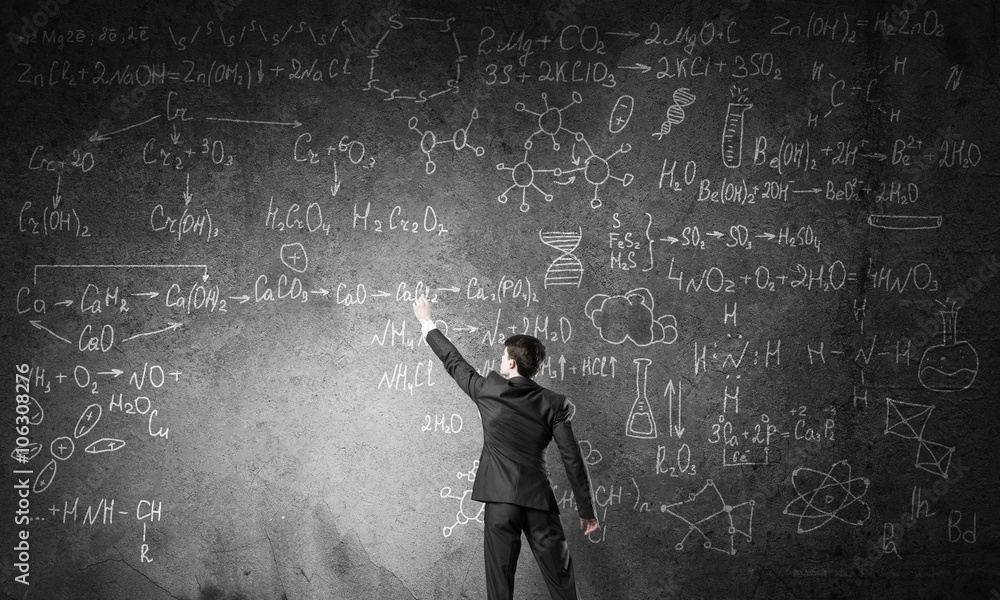 Scientist writing formulas on chalkboard Scientist writing formulas on chalkboard