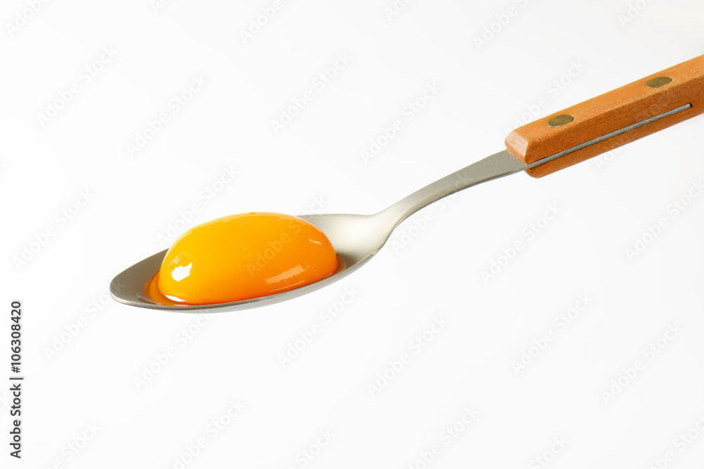 Raw egg yolk on spoon Raw egg yolk on spoon