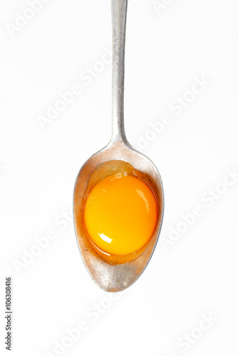 Raw egg yolk on spoon