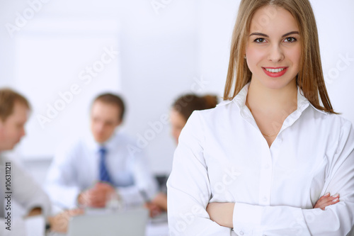 Beautiful business woman on the background of business people during meeting