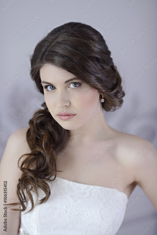Beauty bride in bridal gown indoors. Beautiful model girl in a white wedding dress. Female portrait of cute lady. Woman with hairstyle