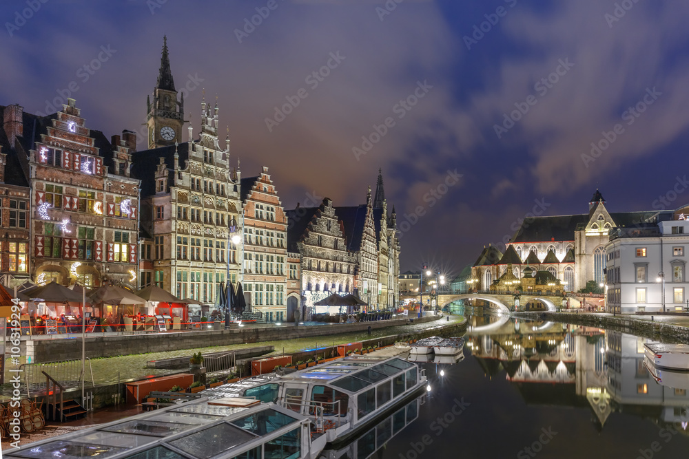 Picturesque medieval building and St Michael's Bridge on the quay Graslei in Leie river at Ghent town at night, Belgium
