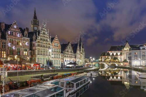 Picturesque medieval building and St Michael's Bridge on the quay Graslei in Leie river at Ghent town at night, Belgium