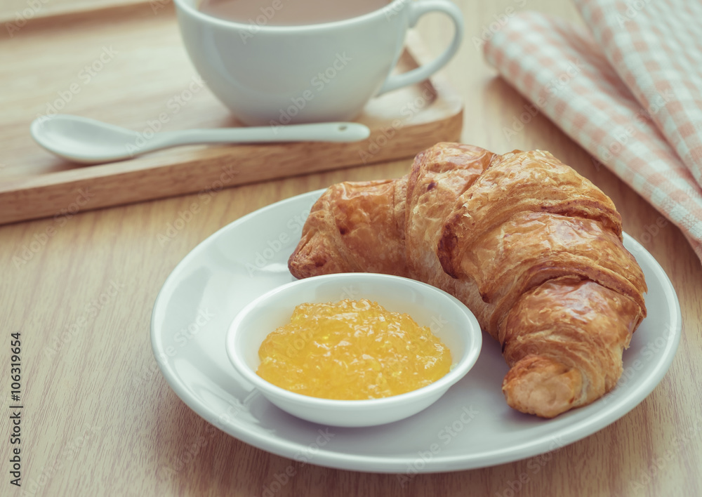 Croissant with jam on plate and coffee cup, Filtered image