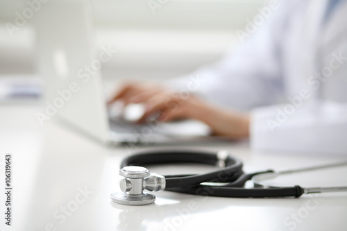 Female doctor typing on laptop, close up © rogerphoto