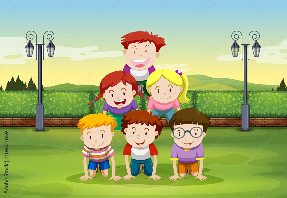 Kids doing human pyramid in the park Kids doing human pyramid in the park
